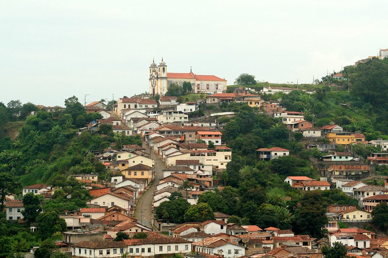 Church on top of hill with houses and streets lining the steep slopes of the hillsides.